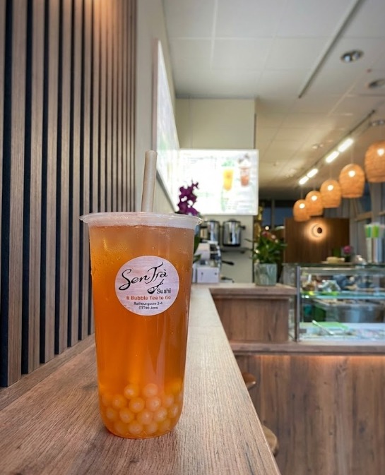 Ausgangsaufnahme eines Bubble-Tea-Bechers auf einer Theke im Innenraum